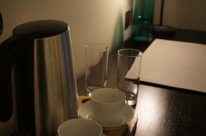 a coffee pot and two glasses on a table at The Maximilian Hotel in Cauayan City