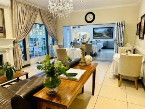 sala de estar con mesa y comedor en Waterkloof Guest House en Pretoria