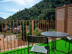 una mesa y sillas en un balcón con una montaña en Domus Lapidis - Villa, en Bogarra