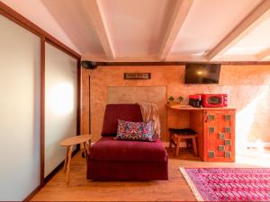 sala de estar con silla roja y mesa en Domus Lapidis - Villa, en Bogarra