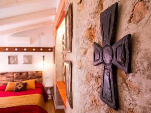 una cruz en la pared de una habitación con 2 camas en Domus Lapidis - Villa, en Bogarra