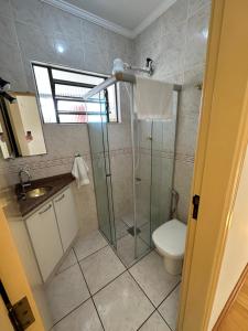 a bathroom with a shower and a toilet and a sink at Apartamento 32 no centro de Águas de São Pedro in Águas de São Pedro