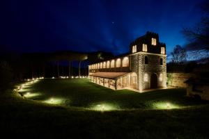 een gebouw met verlichting in een tuin 's nachts bij UNA Hotels Monterufoli Wine Country in Monteverdi Marittimo