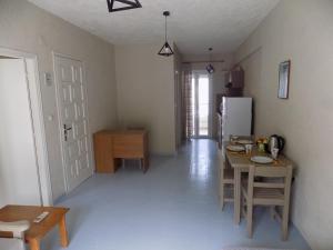 a kitchen and dining room with a table and a refrigerator at Afrodite Spacious Apartments! in Ayia Evfimia