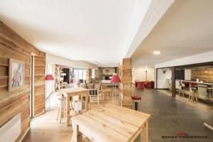 a large room with a wooden table and chairs at appartement 6 personnes proche commerce et remontés mécaniques in Saint-Lary-Soulan