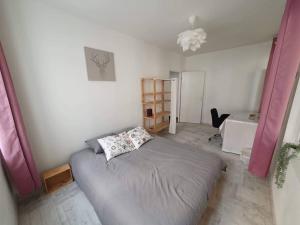 een slaapkamer met een bed in een kamer met roze gordijnen bij Loft, appartement in Morbier