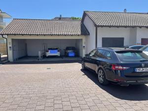 ein Auto, das vor einer Garage geparkt ist in der Unterkunft Gästehaus Mäder Am Hafen in Uhldingen-Mühlhofen
