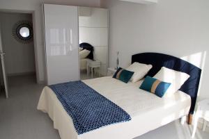 een slaapkamer met een groot bed met blauwe en witte kussens bij GINA Epernay Hyper-Centre 2-4 P in Épernay