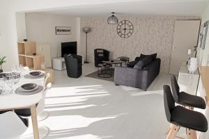 een woonkamer met een bank en een tafel en stoelen bij GINA Epernay Hyper-Centre 2-4 P in Épernay