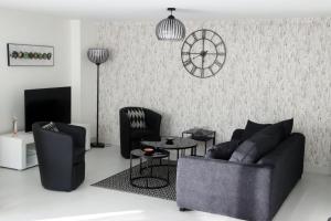 - un salon avec un canapé, des chaises et un réveil dans l'établissement GINA Epernay Hyper-Centre 2-4 P, à Épernay