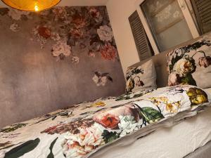 1 dormitorio con 1 cama con flores en la pared en GreenLeaf Walhalla-Apartment - Highspeed WLAN - Netflix - Südbalkon en Tegernheim