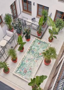 a balcony with a table and potted plants and a rug at Seda Club Hotel - Small Luxury Hotels in Granada