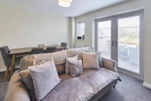 a living room with a brown couch with pillows at Host & Stay - Town House in Seaham