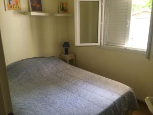 1 dormitorio con cama y ventana en Maison La chambrette, en Le Verdon-sur-Mer