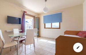 a room with a dining table and a bedroom at Crown apartments in Agia Pelagia