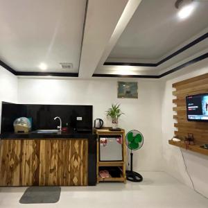 Habitación con cocina con fregadero y TV. en Antipolo Staycation & Transient Affordable Condo Unit By Myra en Antipolo
