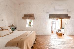 アルテアにあるLa Casa del Aguaの白い壁のベッドルーム1室(大型ベッド1台付)