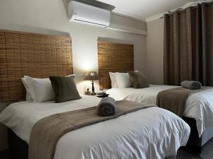 een hotelkamer met 2 bedden en handdoeken erop bij Moya-Sky in Komatipoort