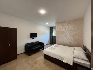 una camera con letto, sedia e televisore di Apartmani Bosfor a Niška Banja