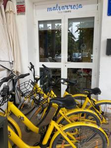 a group of yellow bikes parked in front of a store at Malvarrosa Beach Rooms in Valencia