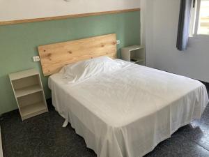 Malvarrosa Beach Rooms في فالنسيا: غرفة نوم بسرير ابيض بجدار اخضر