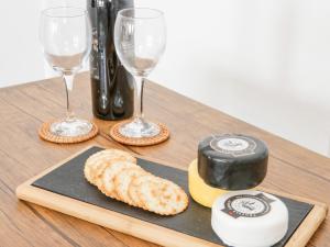 a wooden table with wine glasses and cheese and crackers at Ty Arth in Llandudno