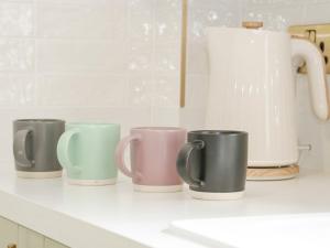 a row of coffee mugs sitting on a kitchen counter at Ty Arth in Llandudno