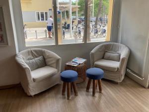 Habitación con 2 sillas, mesa y 2 taburetes en Malvarrosa Beach Rooms, en Valencia