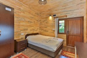 A bed or beds in a room at Cinderella Pension & Bungalow