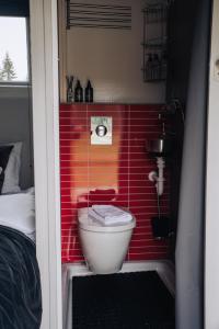 a bathroom with a red tiled wall with a toilet at Golden Circle Truck Hotel in Selfoss