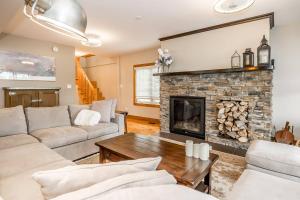 Una sala de estar con un sofá y una chimenea. en Muskoka Lakeshore Cottage Bliss, en Gravenhurst