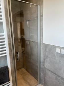 um chuveiro com uma porta de vidro na casa de banho em Leevke em Lastrup
