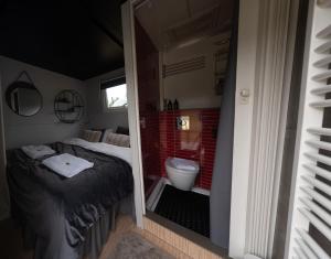 ein Schlafzimmer mit einem Bett und ein Badezimmer mit einem WC in der Unterkunft Golden Circle Truck Hotel in Selfoss