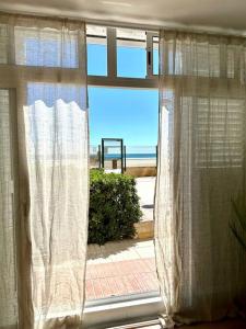a window with a view of the beach at Apartamento Boutique en la Playa in La Pineda