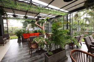 une serre avec des plantes, des tables et des chaises dans l'établissement PrideInn Westlands Luxury Boutique Hotel, à Nairobi