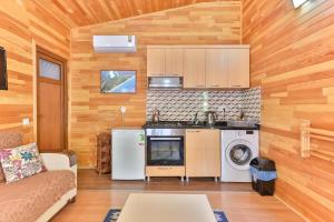 a living room with a couch and a kitchen at Cinderella Pension & Bungalow in Cıralı