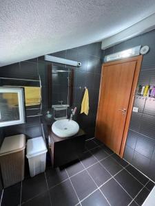 baño con lavabo y puerta de madera en Apartment Crocus of Rafailovici en Budva