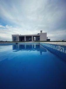 een groot blauw zwembad voor een gebouw bij Excelente Casa Country in Oliden