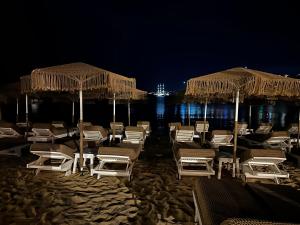 un gruppo di sedie e ombrelloni su una spiaggia di notte di Agia Anna Beachfront Boutique a Paraga