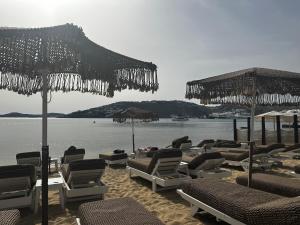 un mucchio di sedie e ombrelloni su una spiaggia di Agia Anna Beachfront Boutique a Paraga