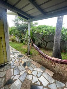 a patio with a hammock outside of a house at Bungalow Les Coraux in La Saline les Bains