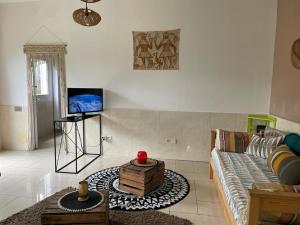 a living room with a couch and a tv at Bungalow Les Coraux in La Saline les Bains