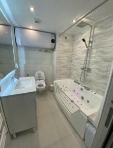 een badkamer met een bad, een toilet en een wastafel bij Manhattan apartment in Empuriabrava