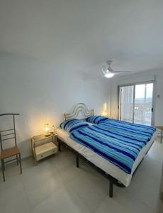 a bedroom with a bed and a chair and a window at Manhattan apartment in Empuriabrava