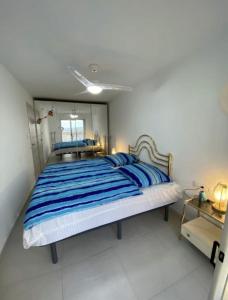 a bedroom with a large bed with blue and white sheets at Manhattan apartment in Empuriabrava