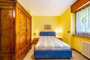アオスタにあるCasa Margheritaのベッドルーム1室(ベッド1台付)、大きな木製キャビネットが備わります。