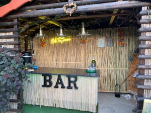 a bar in a bamboo building with a bar sign at Petit Luxe in Mortroux