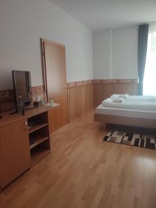 um quarto com uma cama e uma televisão de ecrã plano em Park Hotel em Nagyatád