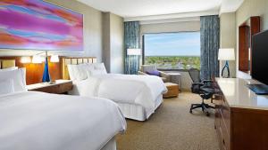 a hotel room with two beds and a large window at The Westin Chicago Northwest in Itasca
