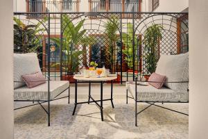 a room with two chairs and a table with drinks on it at Seda Club Hotel - Small Luxury Hotels in Granada